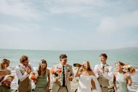 Ben wearing a light suit with a coral and white wedding buttonhole