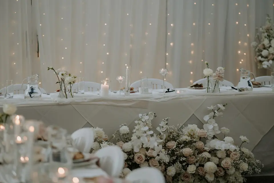 Blush and ivory wedding flowers arranged in bud vases for a refined reception tablescape