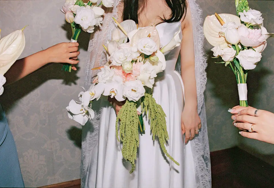 Claire carrying her sculptural wedding bouquet in a film photograph