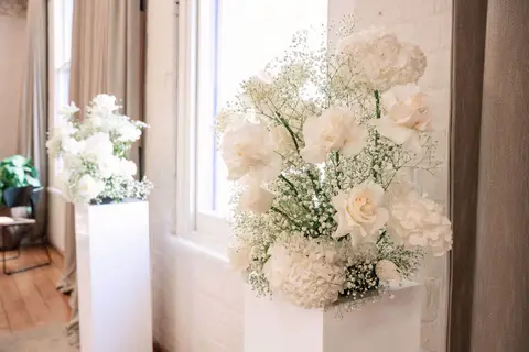 Cloud like white rose hydrangea and babys breath plinth arrangement