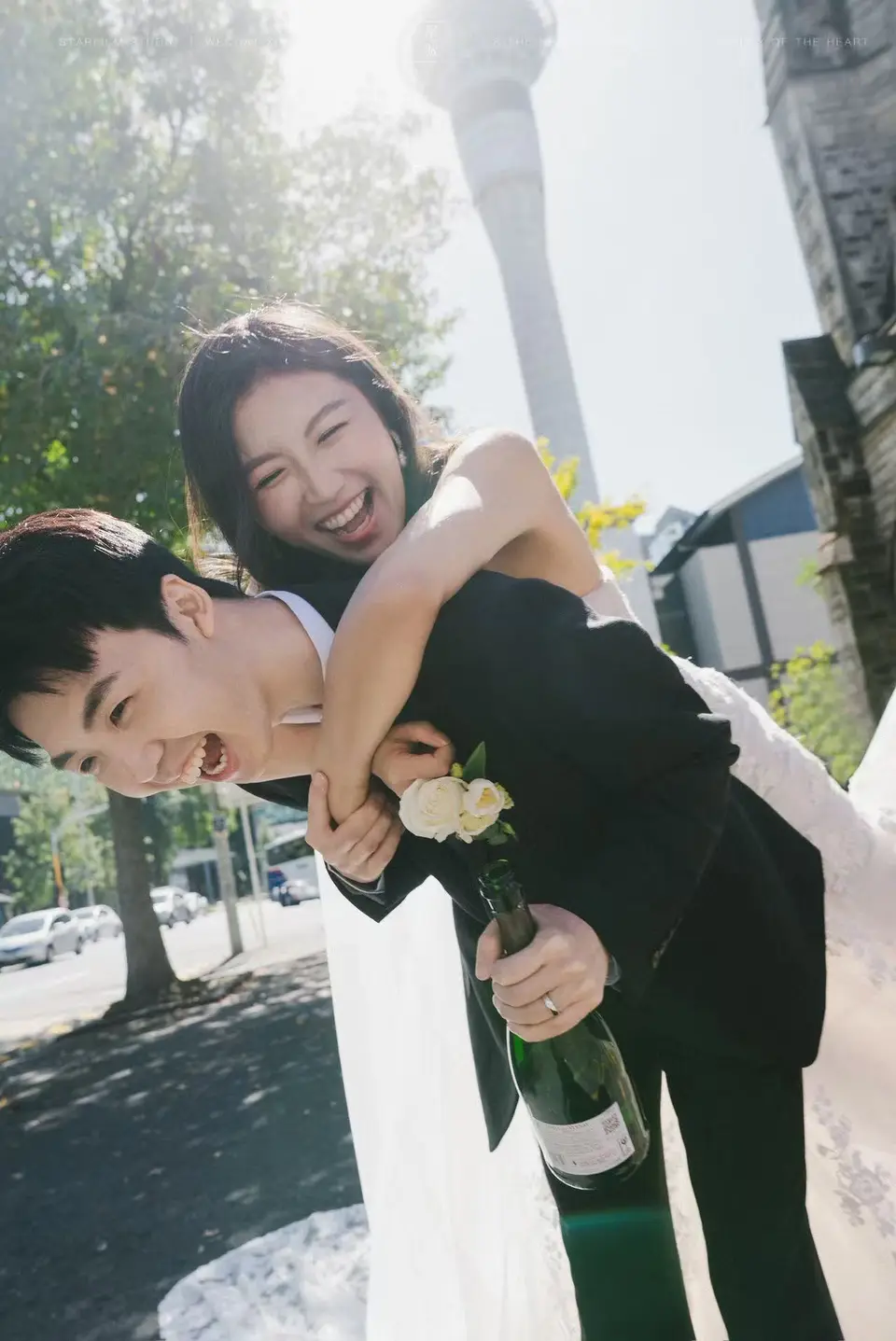Kaelan and Tongtong celebrating with champagne outside St Matthew-in-the-City