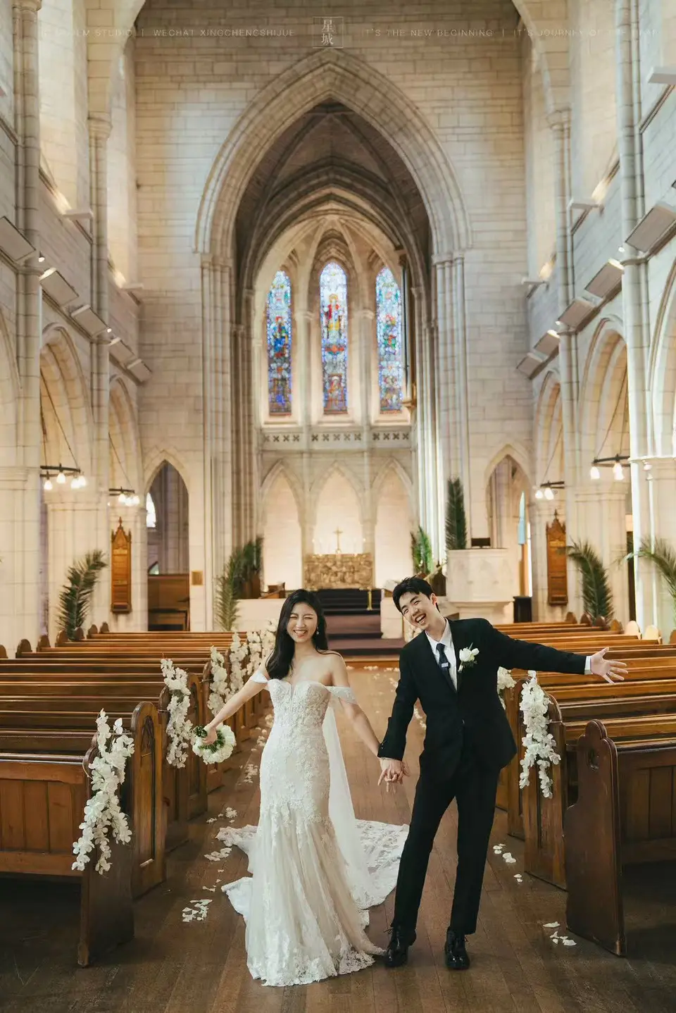 Kaelan and Tongtong walking through the flower-lined church aisle