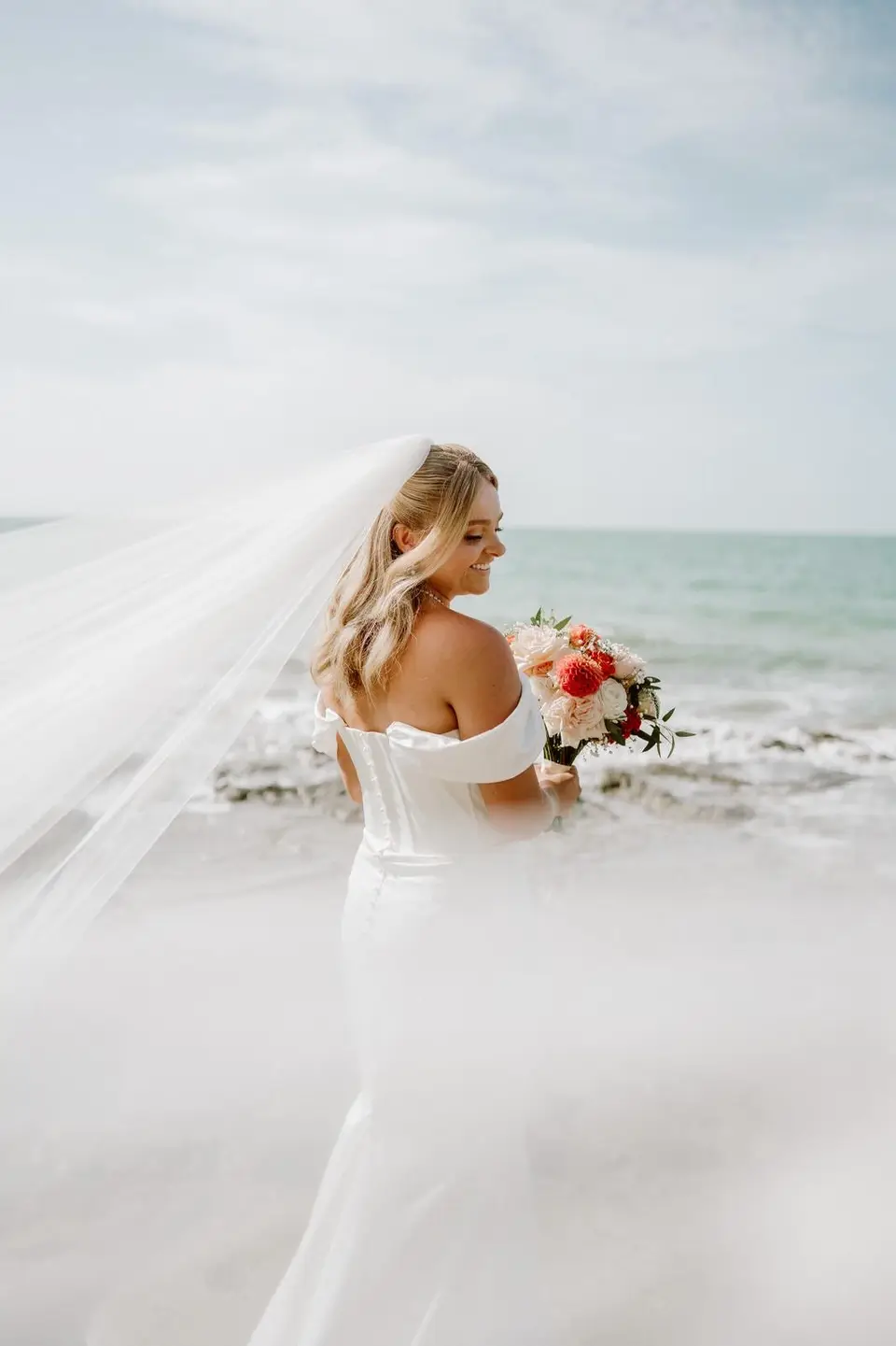 Kate and Ben standing on the beach after their wedding at The Officers Mess Takapuna
