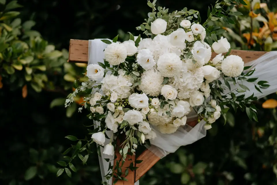 Outdoor estate wedding ceremony with white floral styling