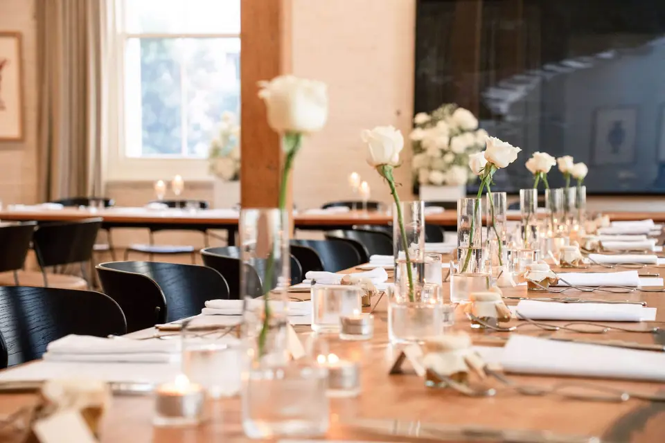 Single white rose bud vases and candlelight on the reception tables