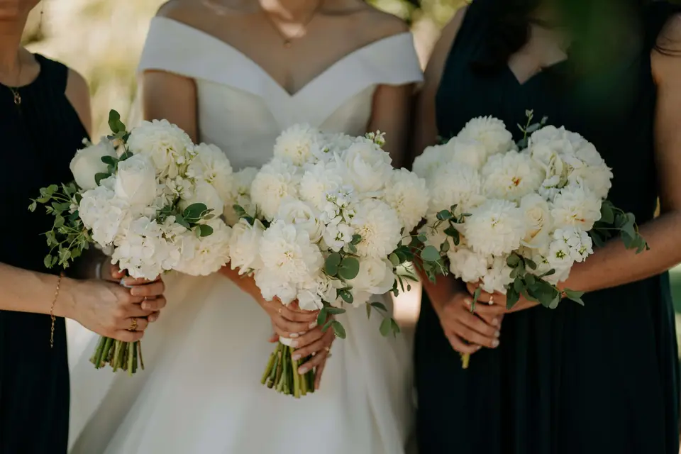 White bridesmaids bouquets with deep green dresses