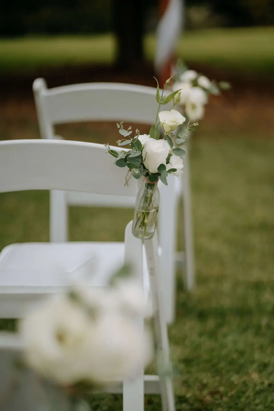 White chair flowers repurposed on guest reception tables